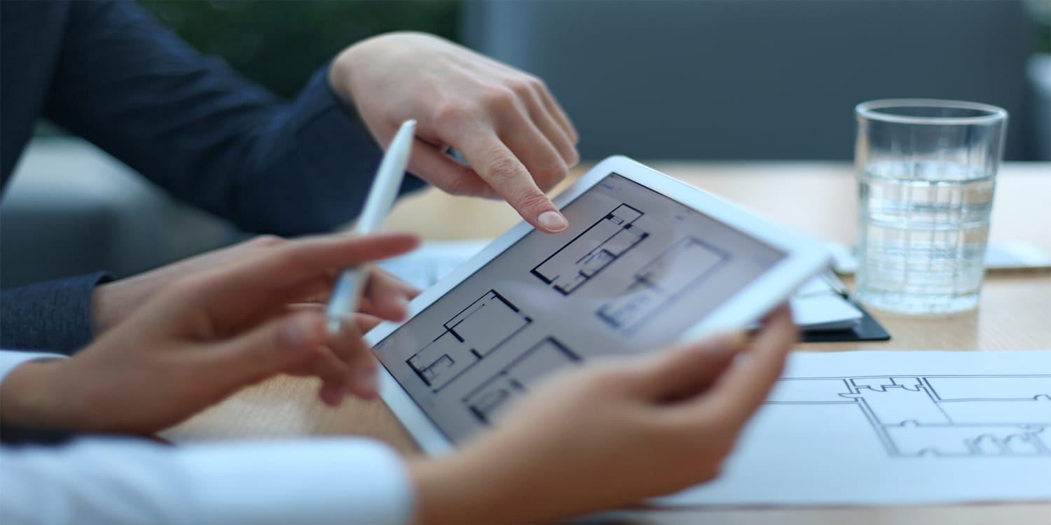 Property manager and landlord reviewing floor plans